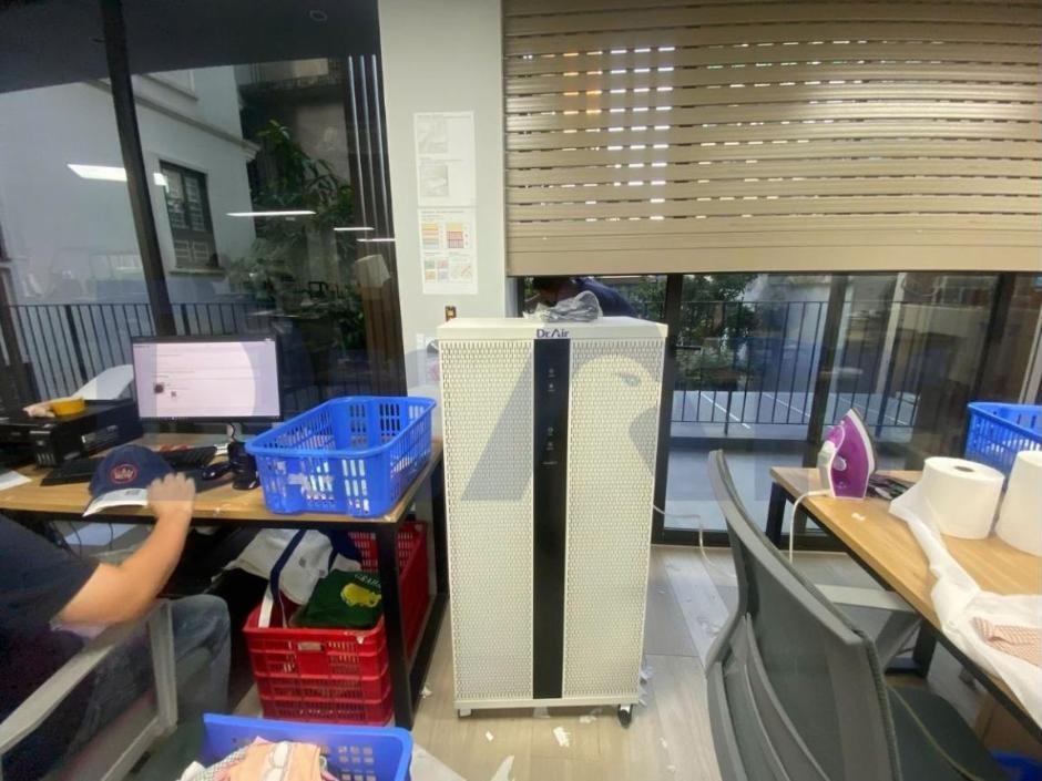 Máy lọc không khí Dr.Air DF150 Plus đặt giữa khu bàn làm việc và khu là ủi sản phẩm trong xưởng